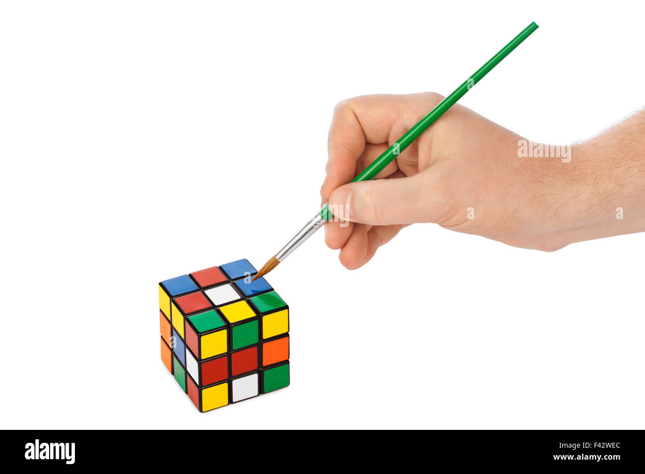 Mano con pennello e cubo puzzle Foto Stock
