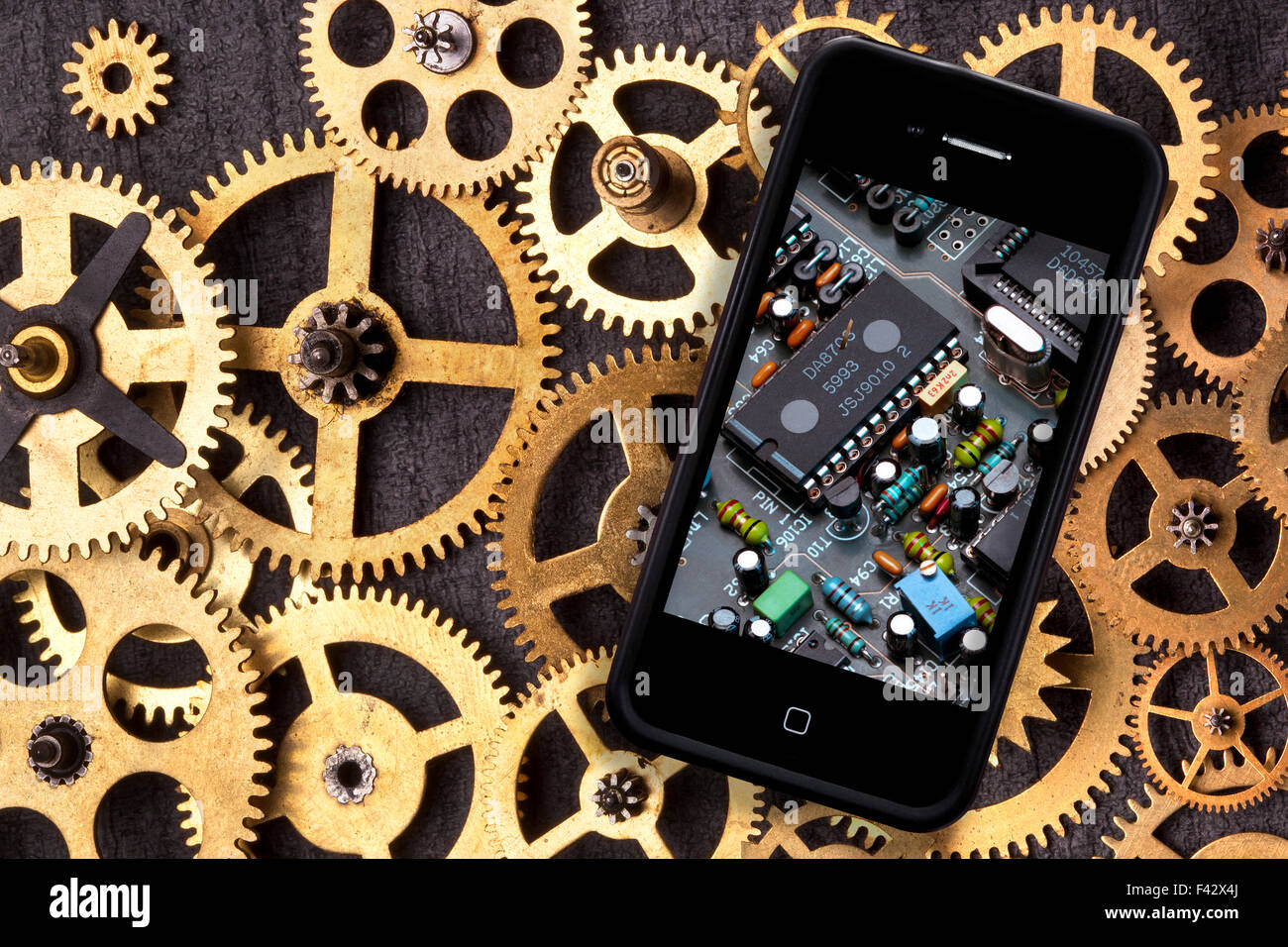 La vecchia e la nuova tecnologia - vecchio orologio di denti e ingranaggi e di uno smartphone con la tecnologia digitale Foto Stock