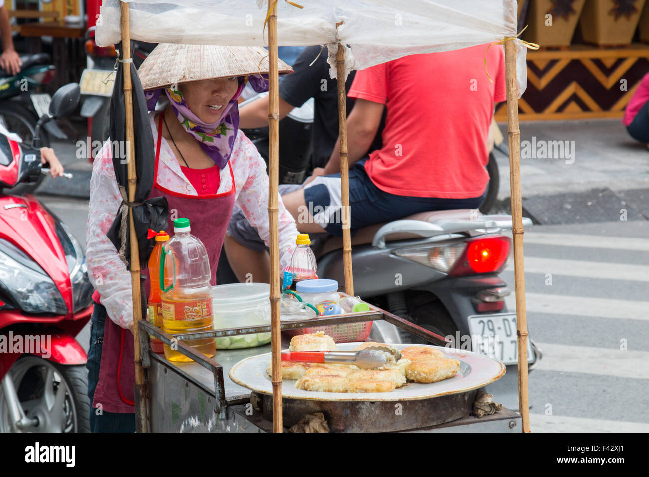 Signora vietnamita di Hanoi vende cibo di strada frittelle fritte nel vecchio quartiere,Hanoi,Vietman,Asia Foto Stock
