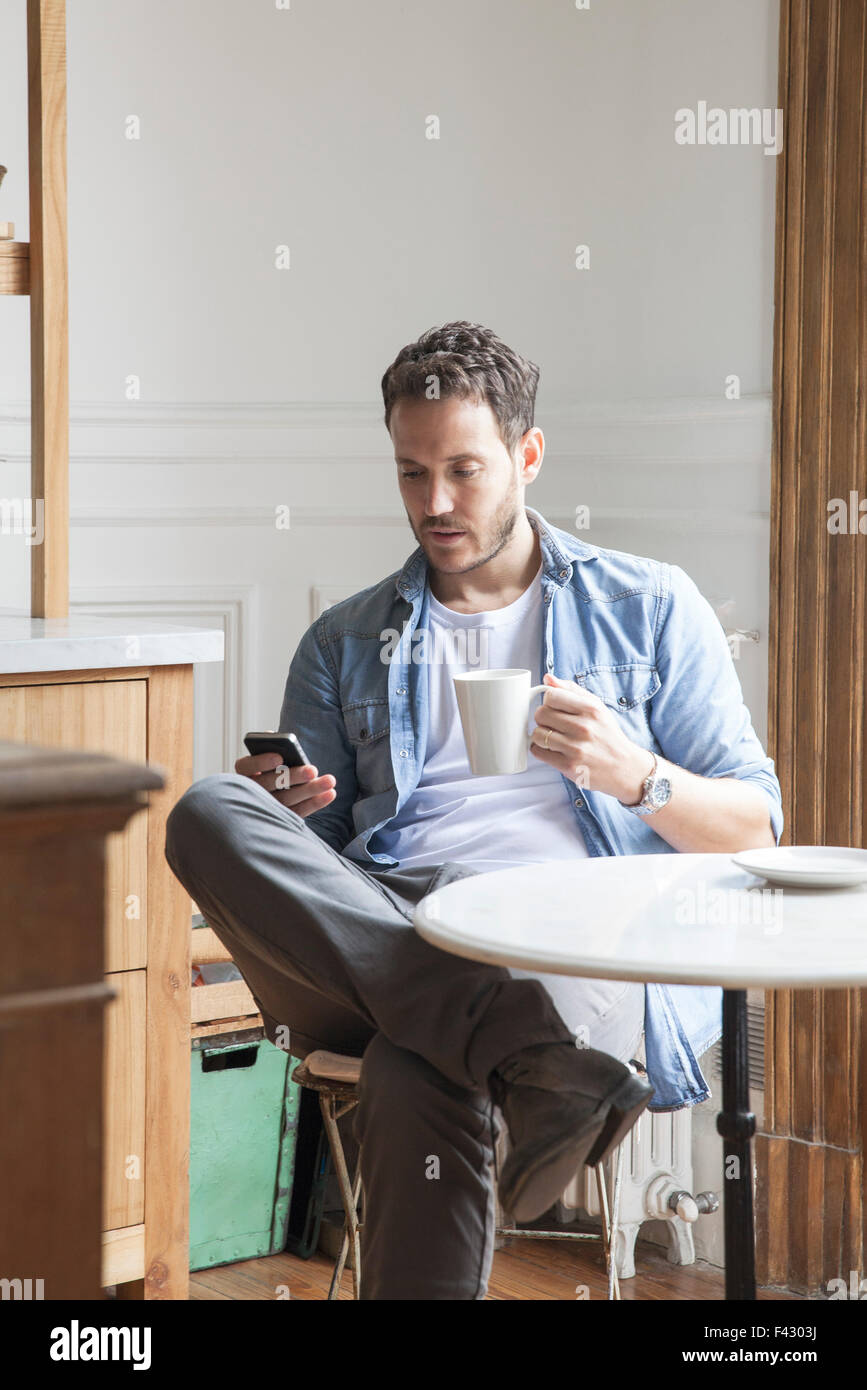 Uomo di inviare un messaggio di testo durante la pausa caffè Foto Stock