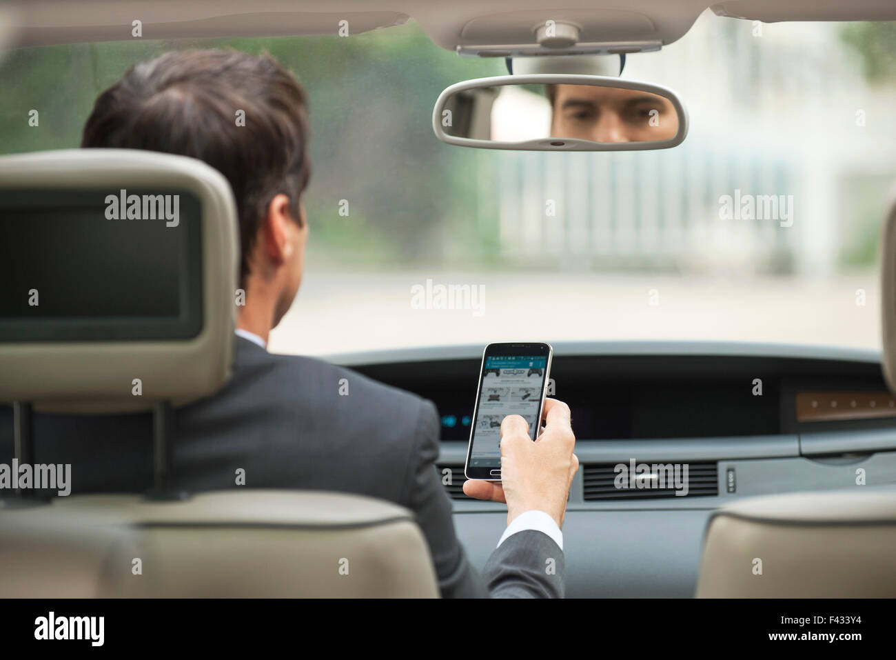 Utilizzando il telefono cellulare mentre si guida auto Foto Stock