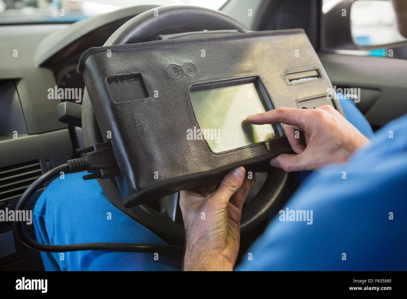 Meccanico con attrezzo di diagnosi in auto Foto Stock