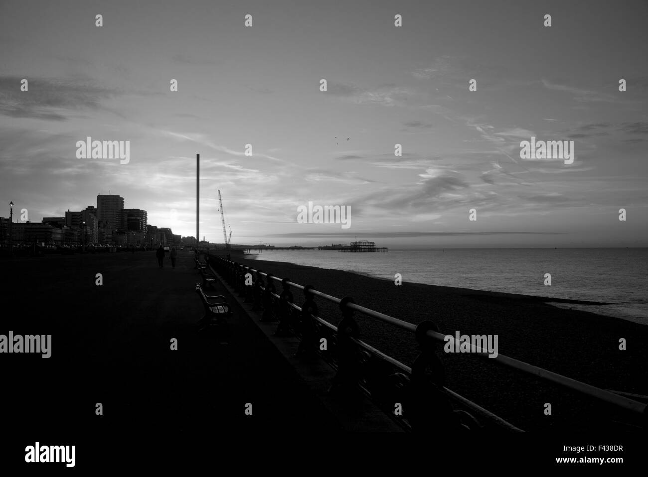 Brighton Seafront promenade e all'alba, i360 torre di avvistamento in costruzione, in bianco e nero Foto Stock