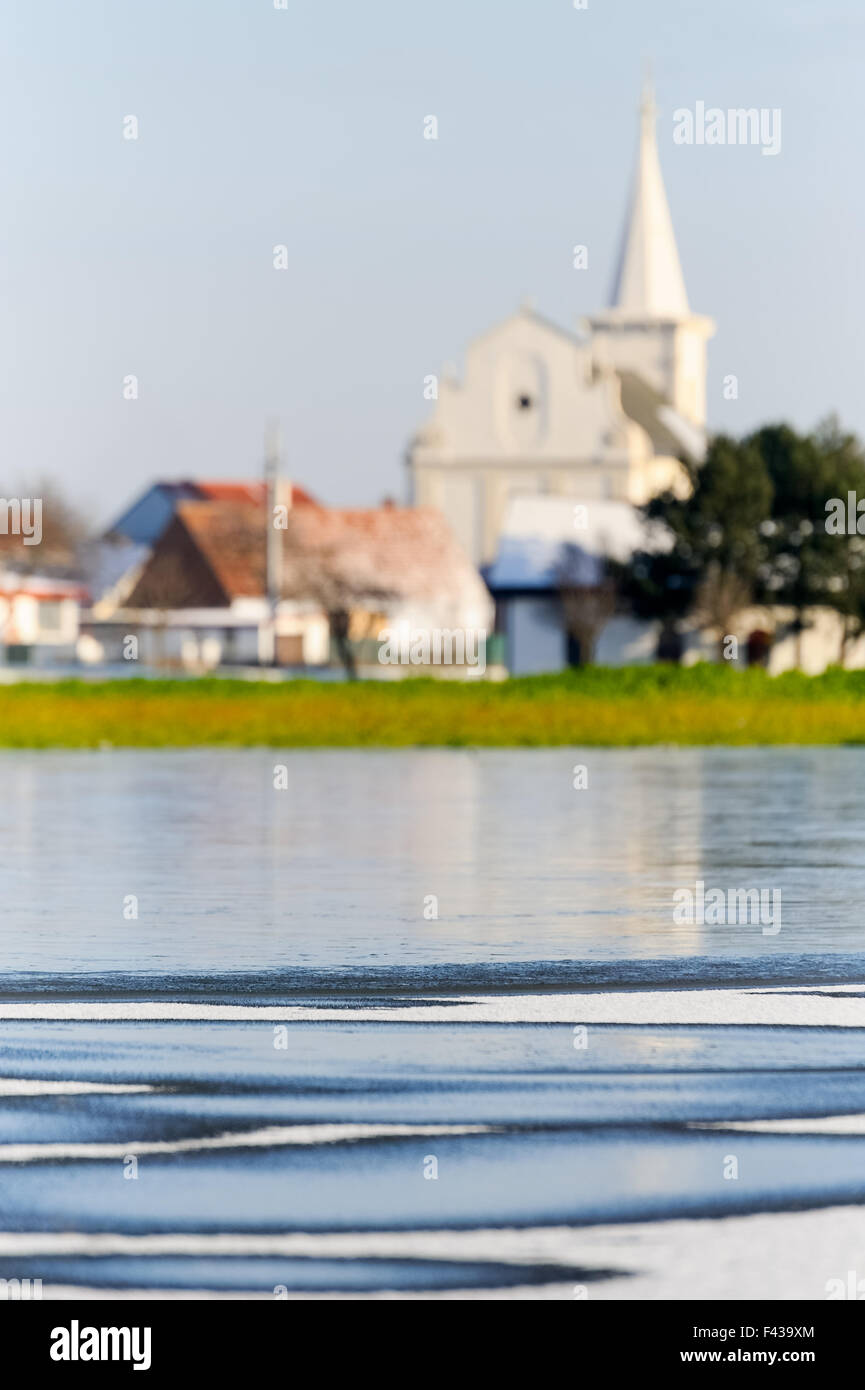 Ghiaccio su un laghetto in background una chiesa Foto Stock