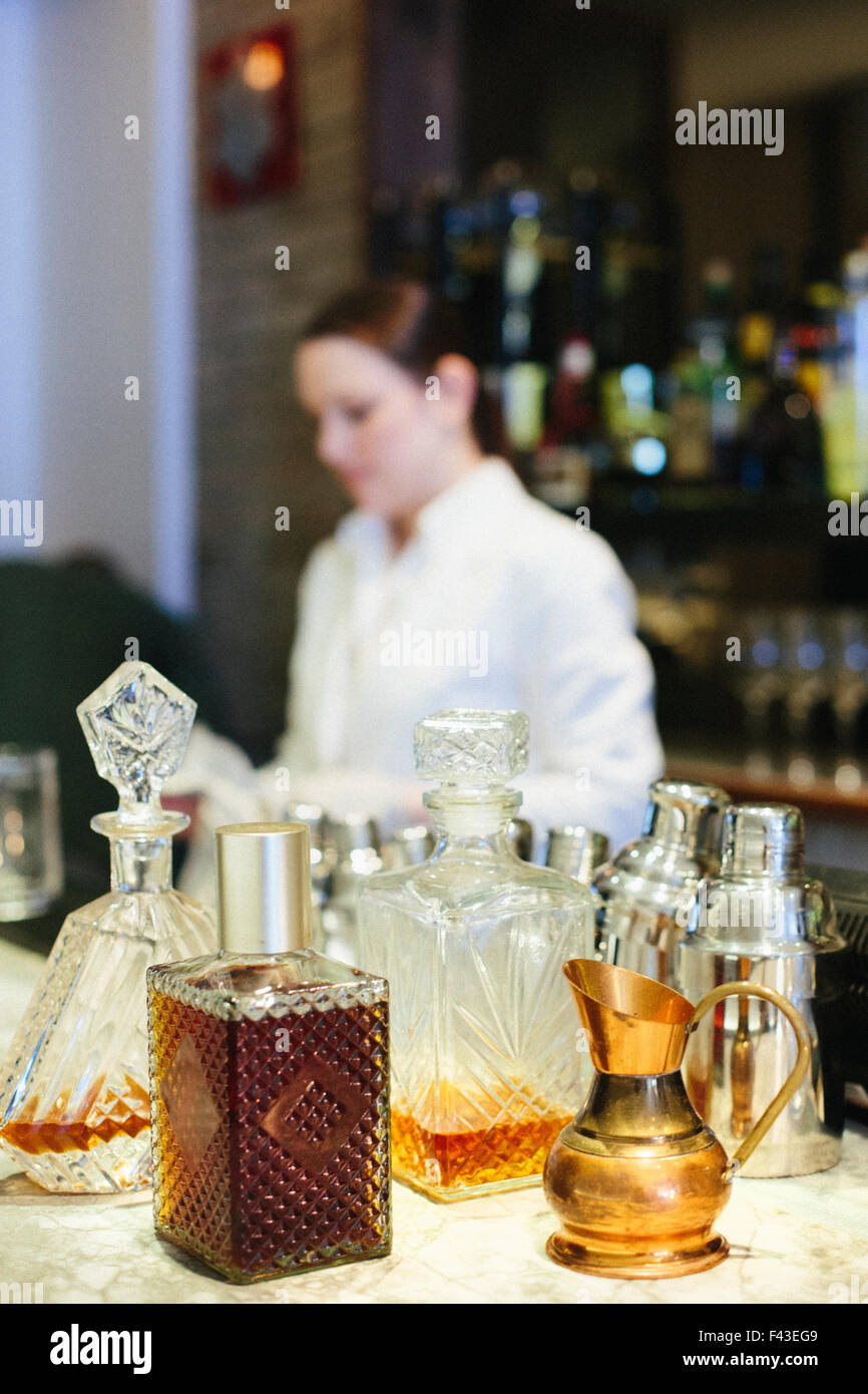 Giovane donna miscelare un cocktail presso il bar in un ristorante della città. Foto Stock Giovane donna miscelare un cocktail presso il bar in un ristorante della città. Foto Stock