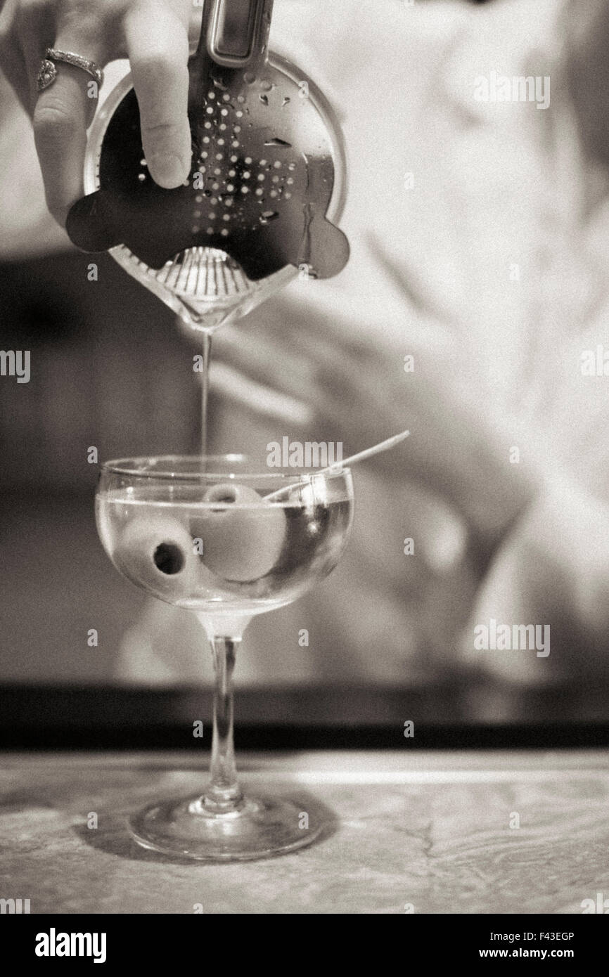 Una donna di miscelare un cocktail, un mixologist al lavoro. Foto Stock