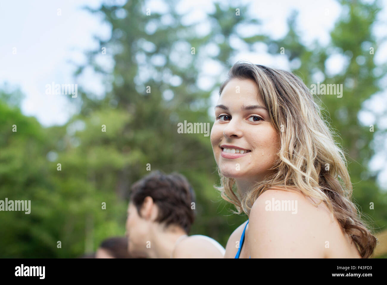 Una giovane donna sorridente e guardando la telecamera. Foto Stock