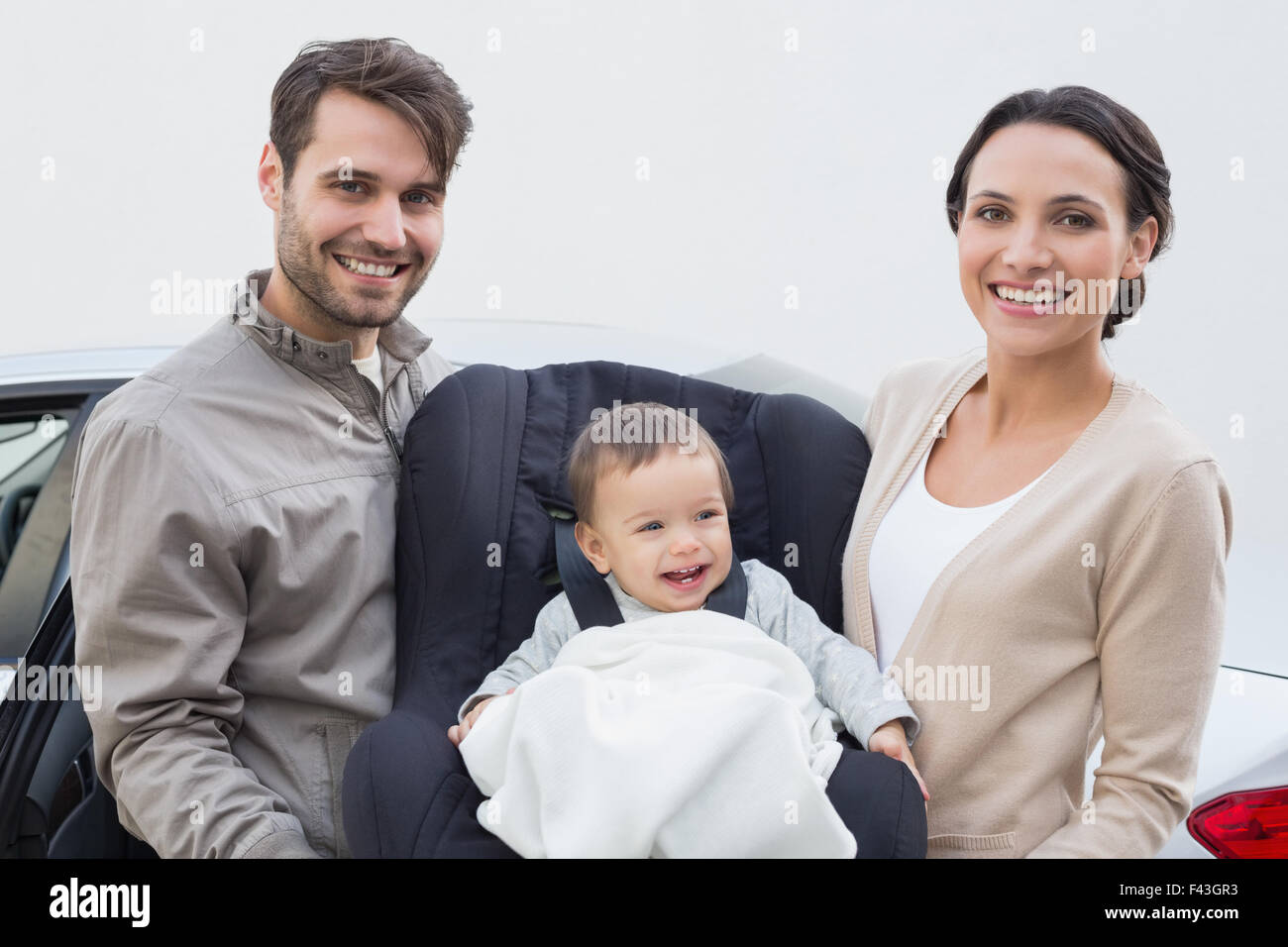 I genitori bambino portando nel suo sedile auto Foto Stock