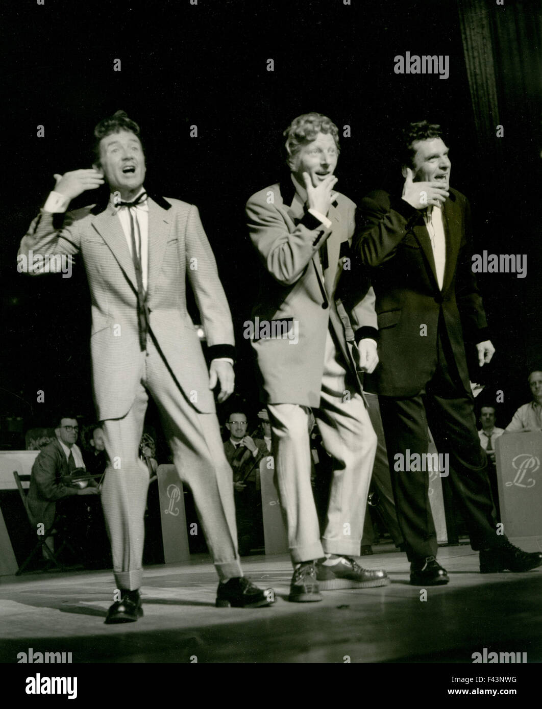 JOHN MILLS con Danny Kaye centro e Laurence Olivier cantare Noel Coward la canzone 'tre capretti delinquenti' al London Palladium in una notte di 100 stelle spettacolo di beneficenza per gli attori orfanotrofio nel gennaio 1955 Foto Stock