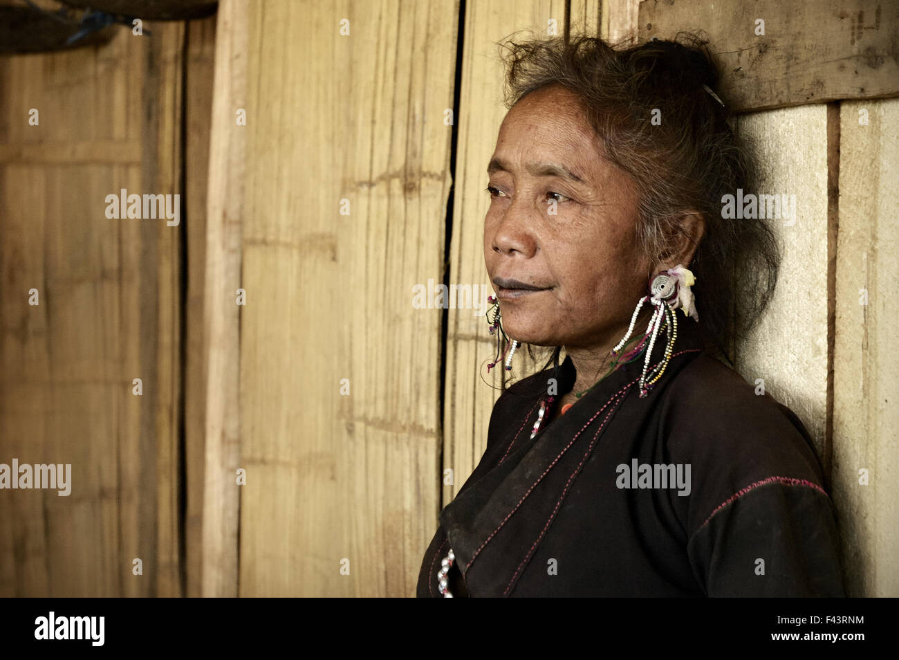 Vecchio Ann donna seduta dentro la sua casa in legno in un villaggio intorno a Kengtung (Kyaingtong), Stato Shan, Myanmar Foto Stock