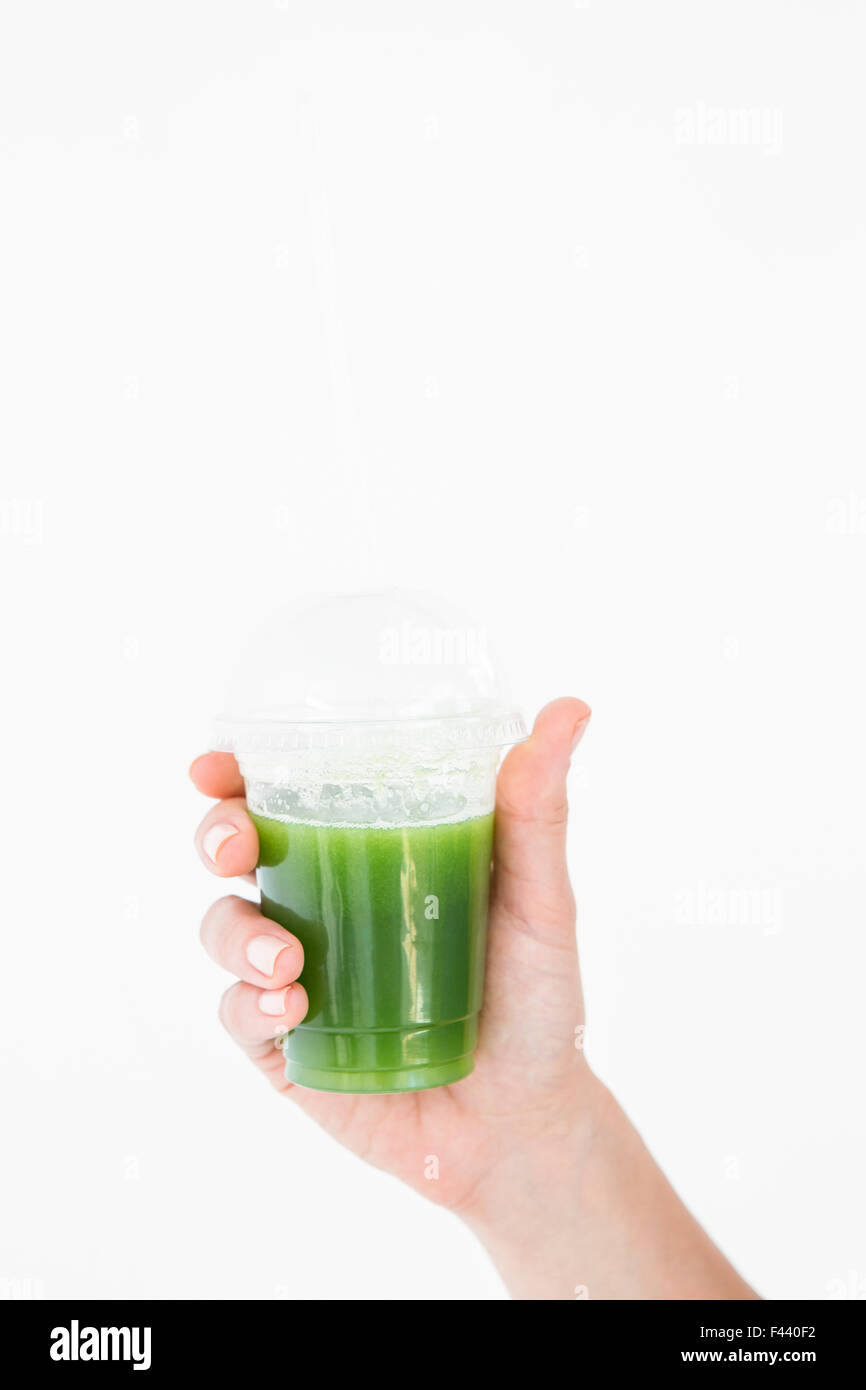 La donna che mostra il succo verde in calice Foto Stock