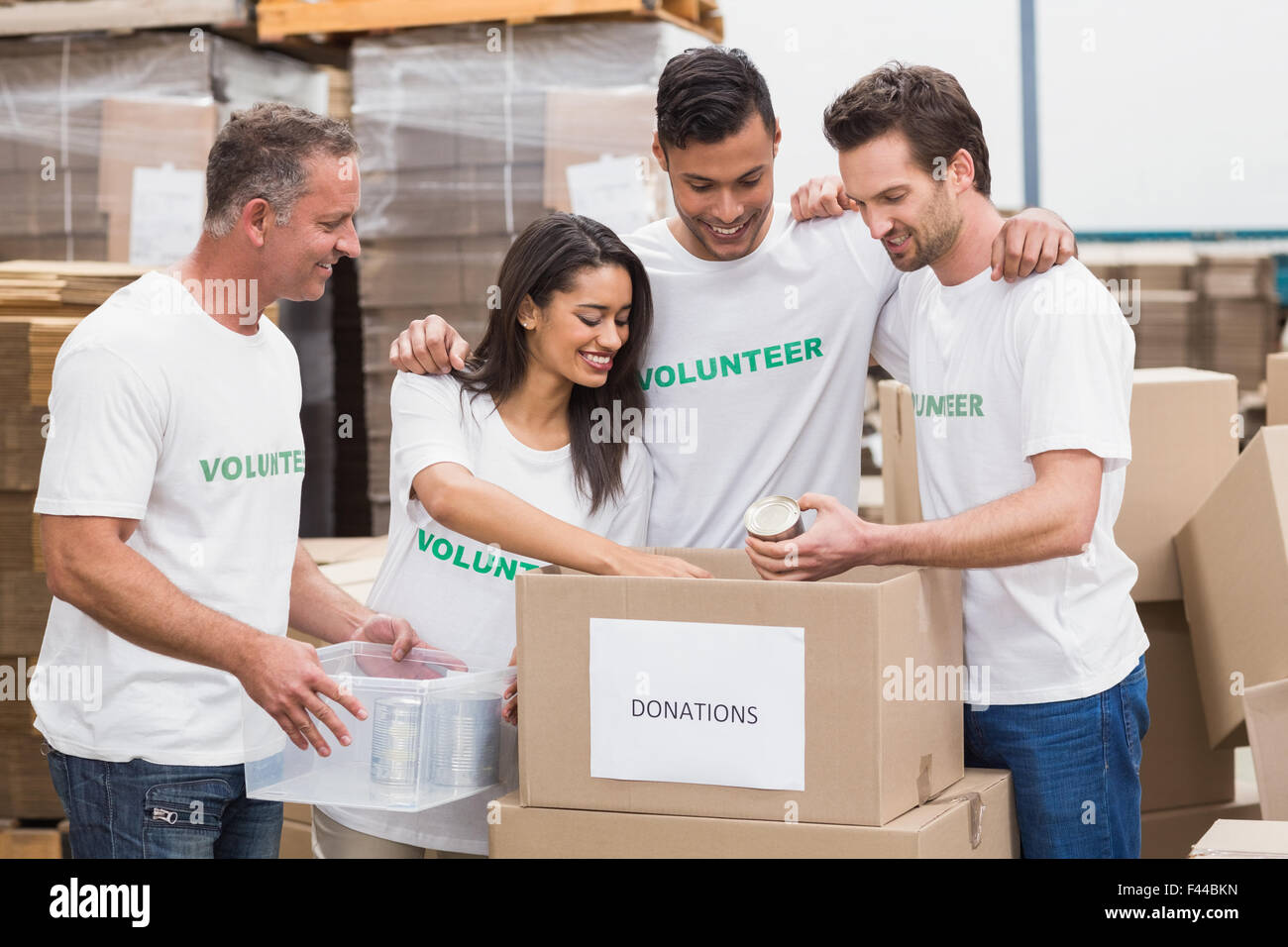 Il team di volontari di imballaggio alimentare una casella di donazione Foto Stock