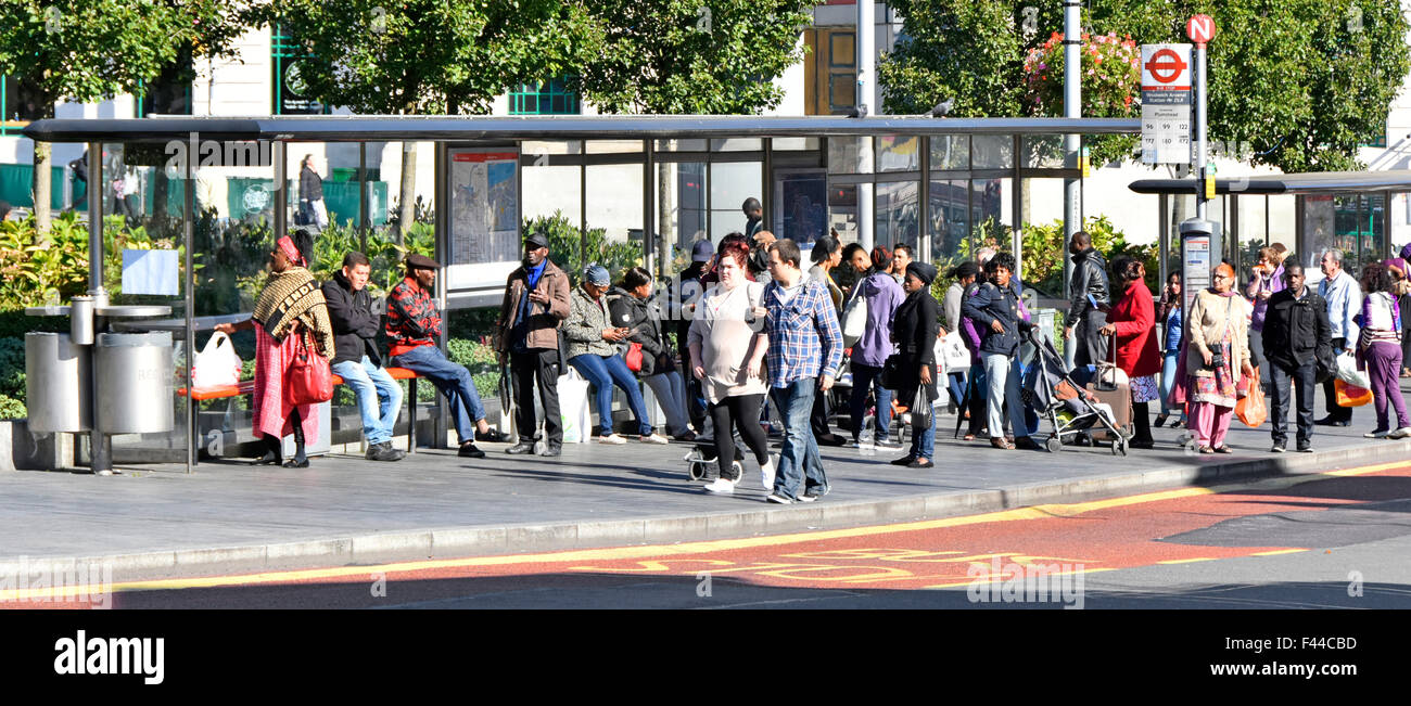 Woolwich London gruppo di passeggeri multirazziali che aspettano in un centro commerciale affollato, fermata dell'autobus, rifugio in Inghilterra, Regno Unito Foto Stock