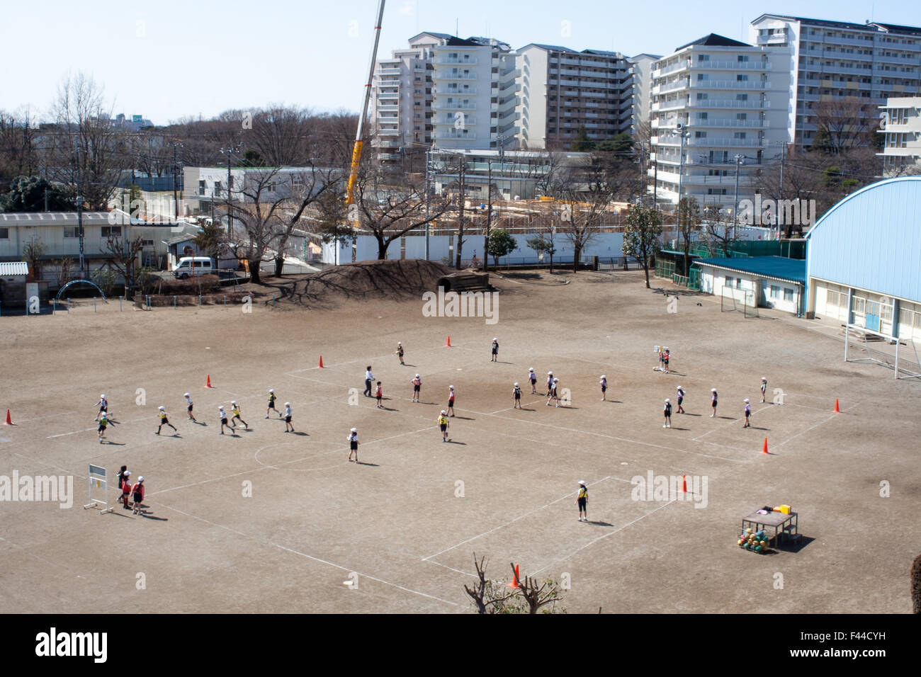 I bambini a giocare sul campo di sporco nel cortile della scuola Foto Stock