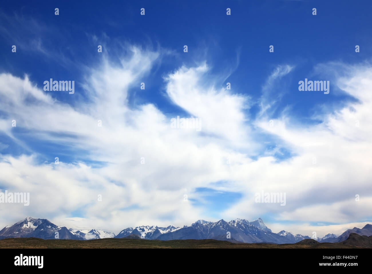 Le nuvole sopra montagne innevate Foto Stock