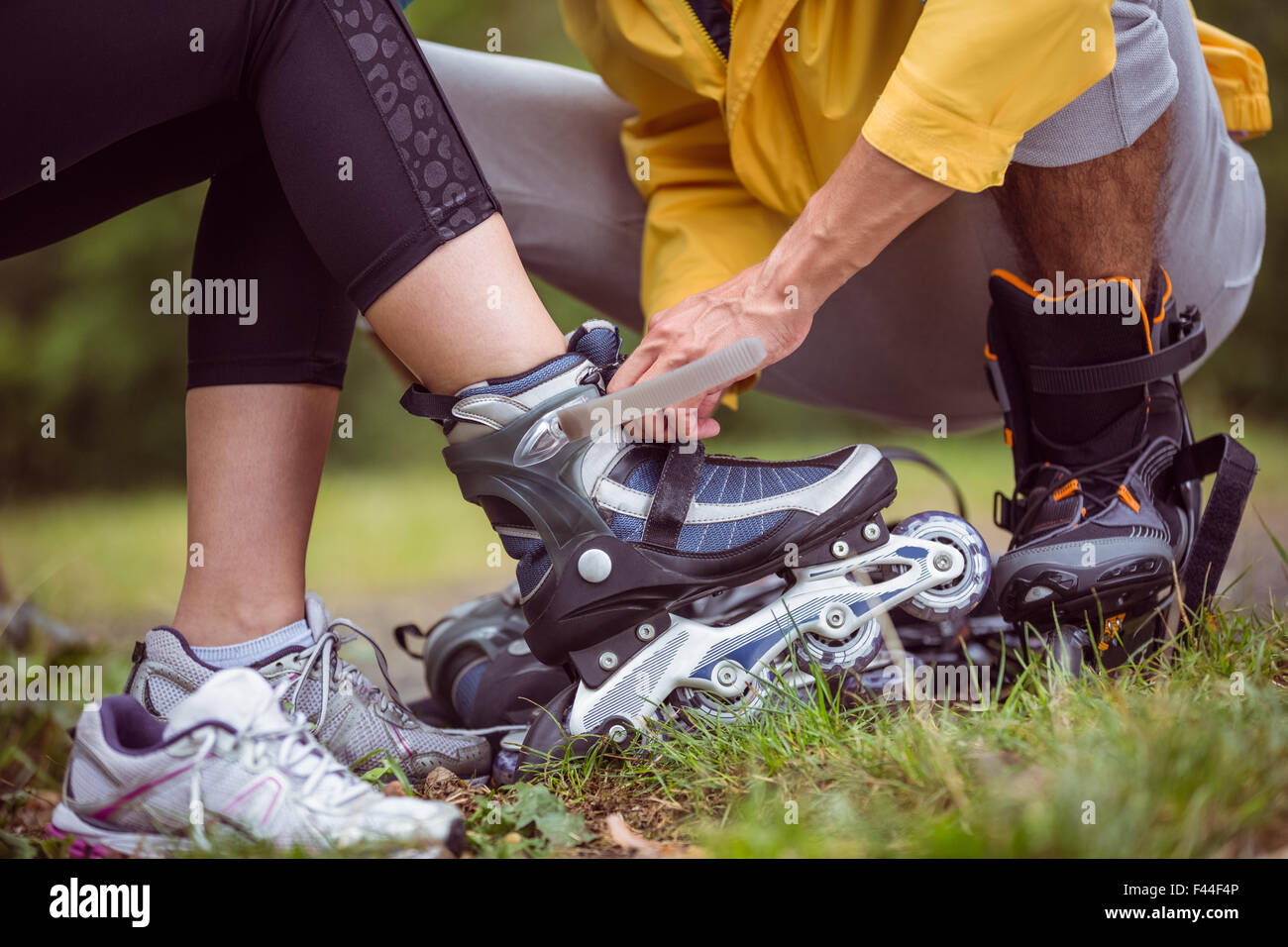 Coppia felice mettendo su lame a rullo Foto Stock