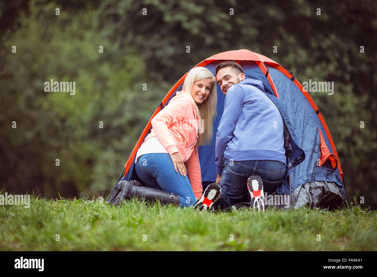 Coppia felice impostazione della loro tenda Foto Stock