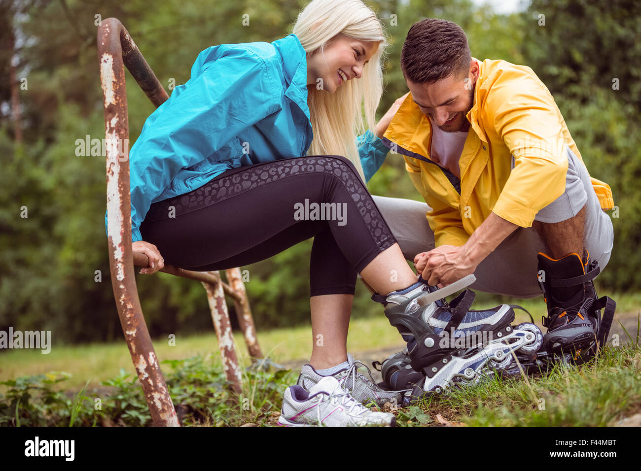 Coppia felice mettendo su lame a rullo Foto Stock
