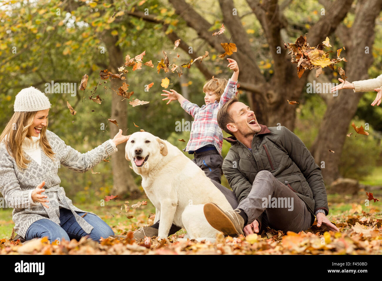 Famiglia giovane con un cane in foglie Foto Stock