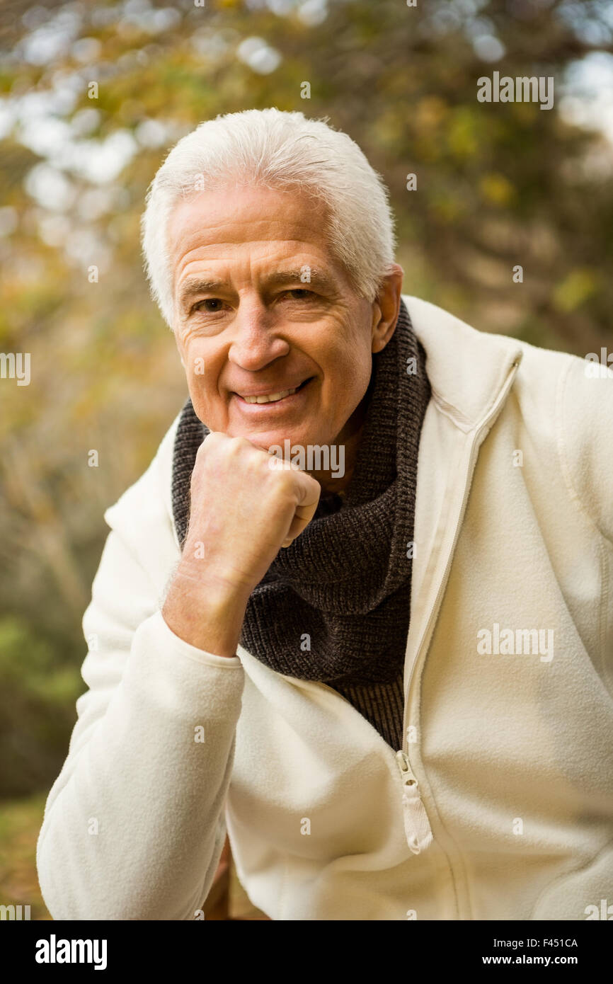 Felice l'uomo senior in posa con la mano sul mento Foto Stock