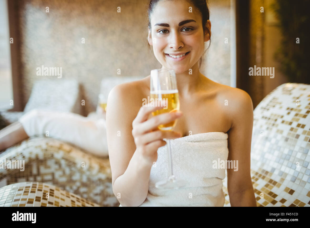 Donna sorridente con in mano un bicchiere di champagne Foto Stock