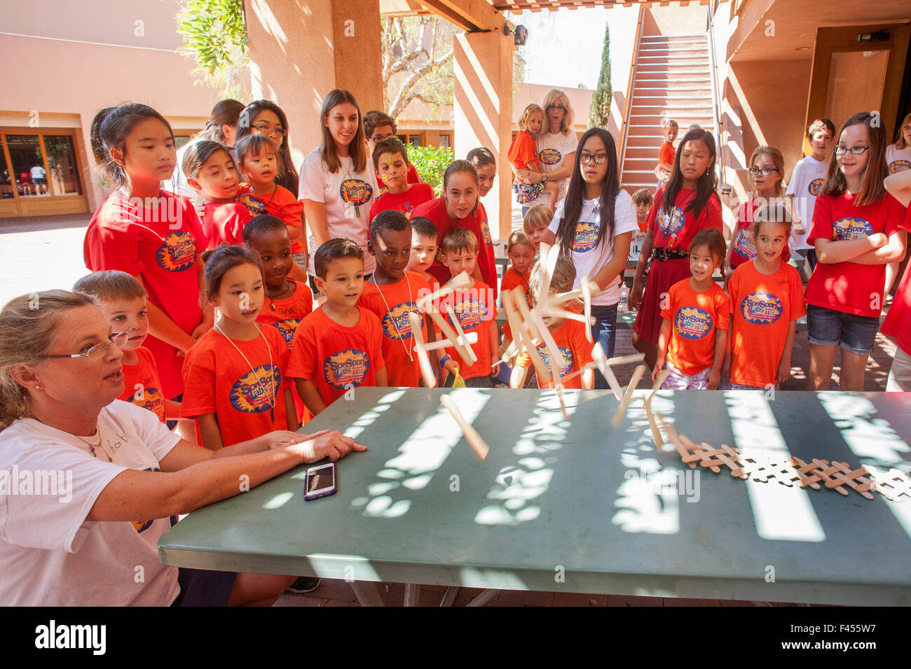 Ghiaccioli bastoni volare come una catena cobra che illustra il piano di un tavolo reazione a catena è dimostrato multirazziale i bambini ad una Laguna Niguel, CA, summer camp. Nota arancione magliette T. Foto Stock