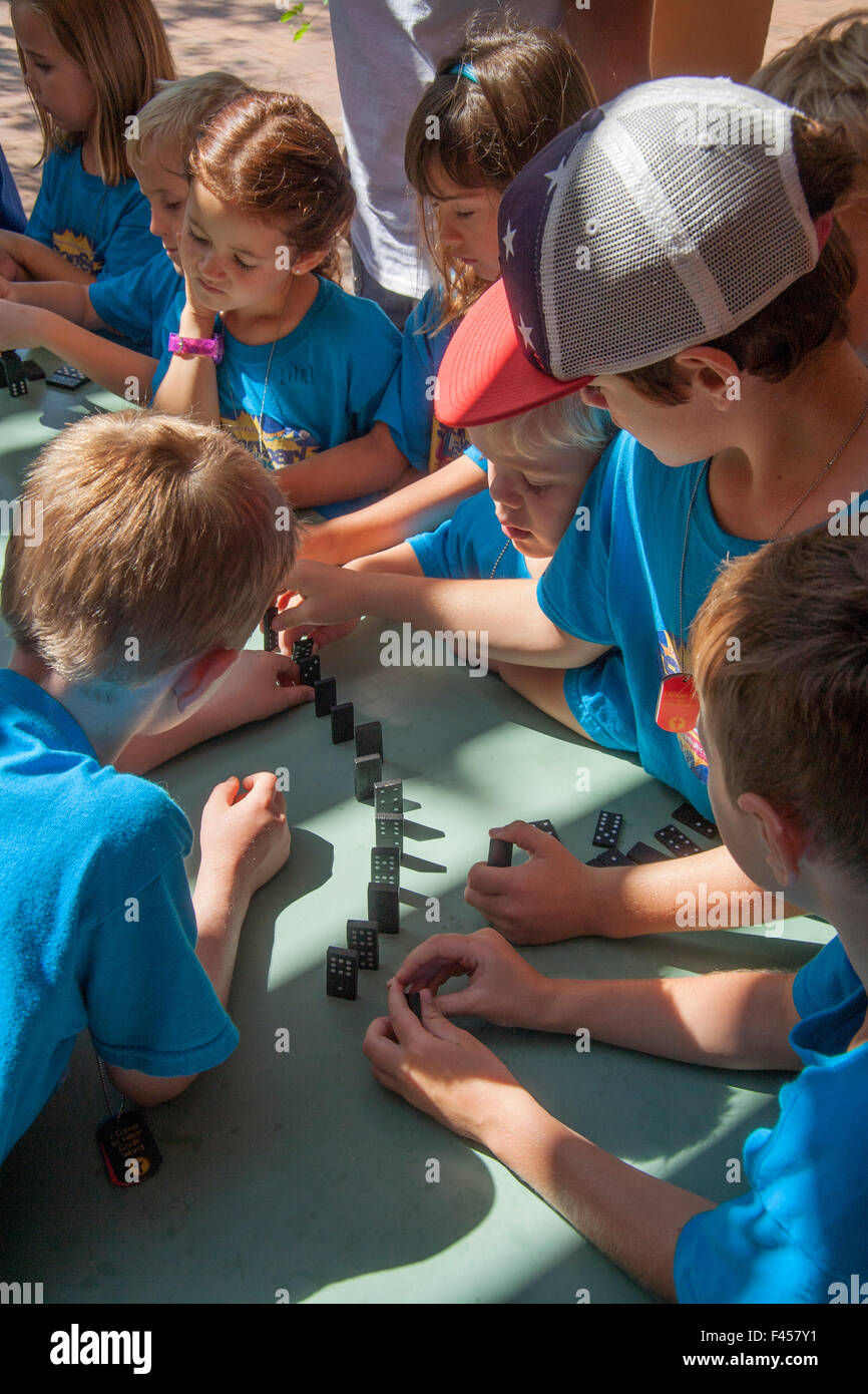 I ragazzi e le ragazze ad una Laguna Niguel, CA, summer day camp line up di domino per illustrare la teoria di una reazione a catena. Foto Stock