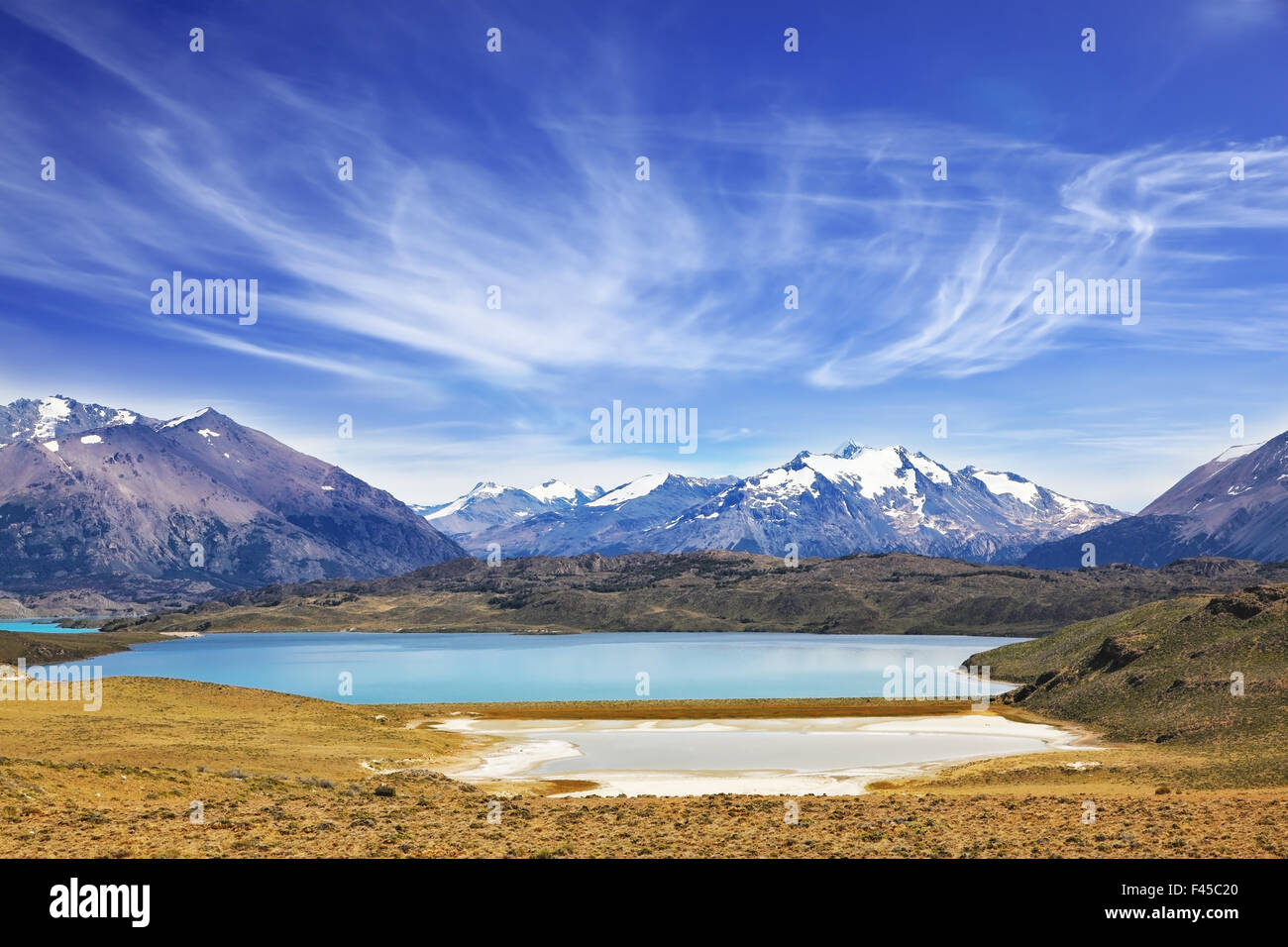 Il lago è circondato da montagne innevate Foto Stock