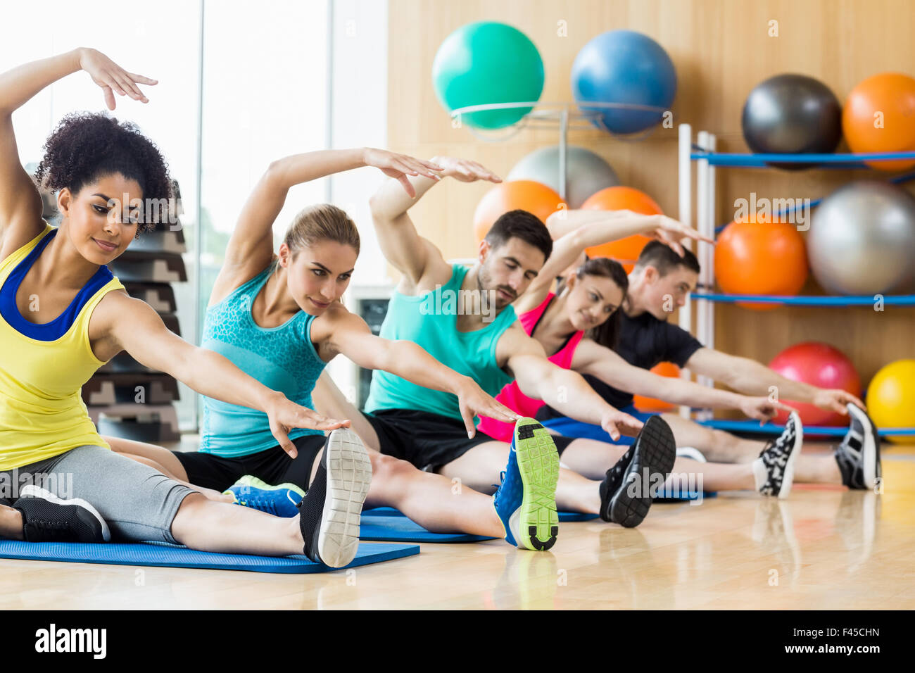 Lezione di fitness che esercitano in studio Foto Stock