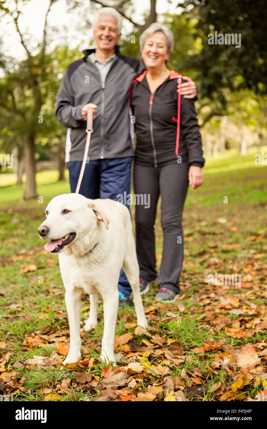 Coppia senior nel parco con il cane Foto Stock