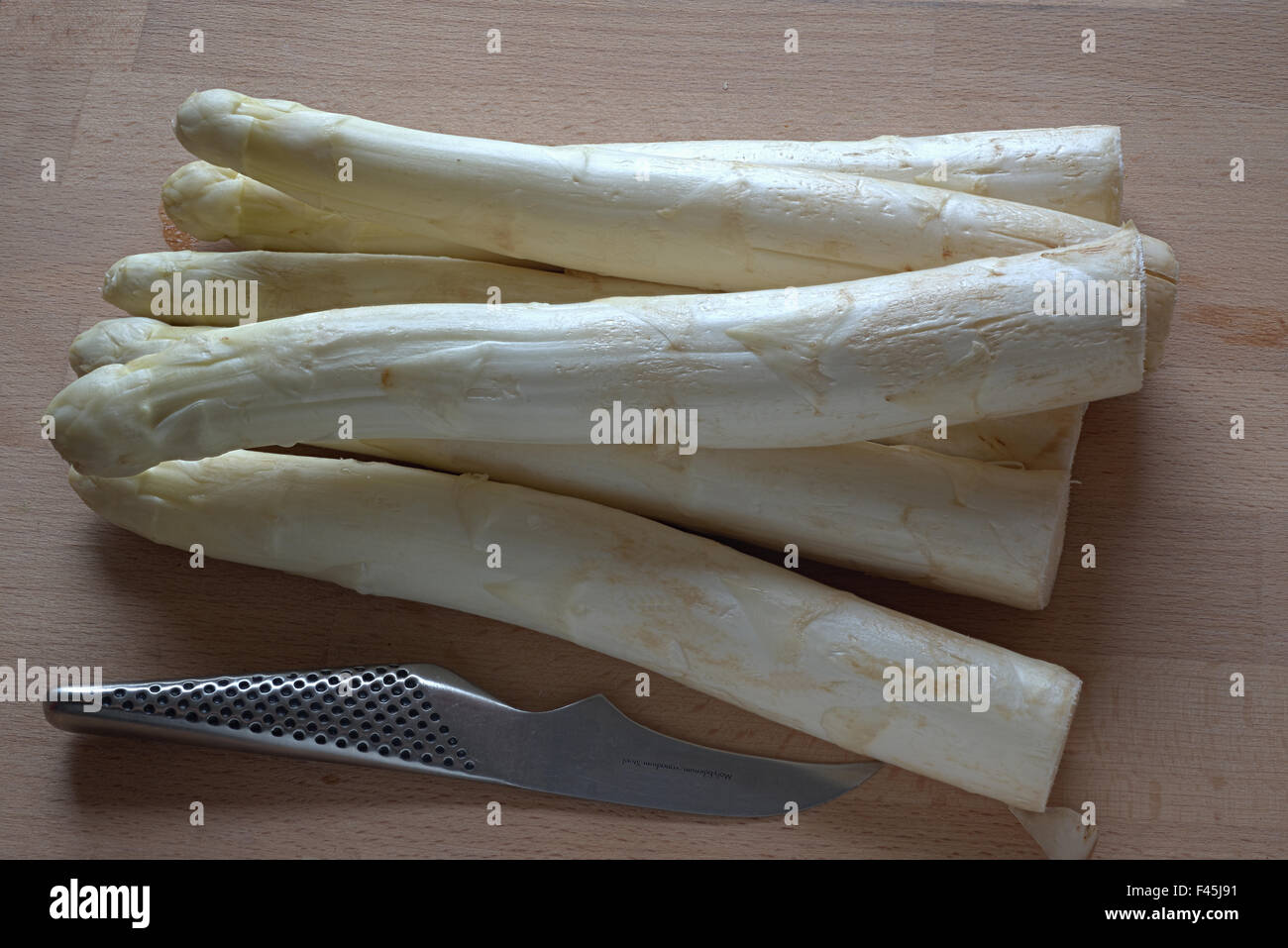 Gli asparagi e coltello sulla tavola di legno Foto Stock