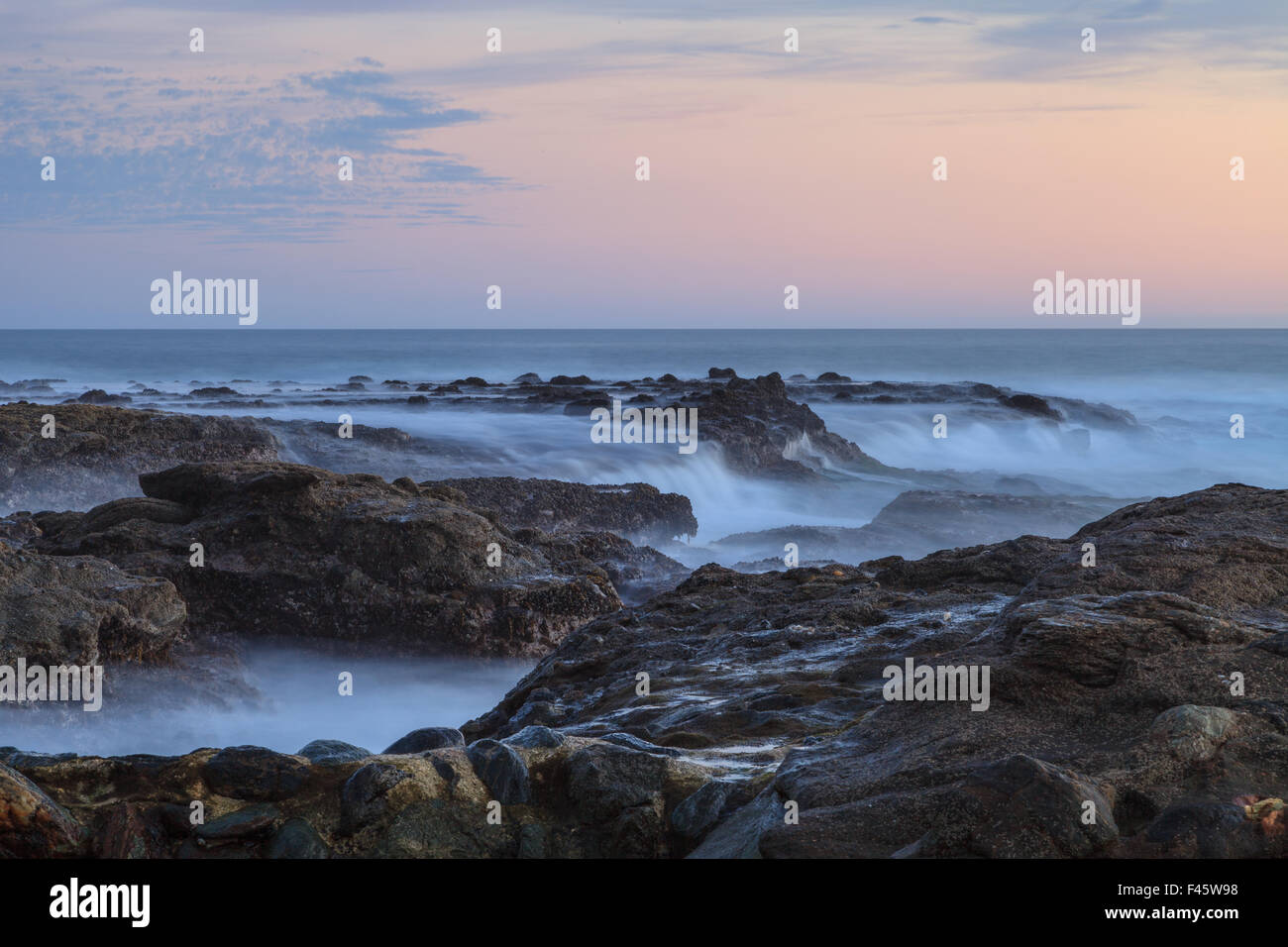 Tramonto sulle rocce a Shaws Cove nella Laguna Beach come flussi di acqua sopra la pietra Foto Stock