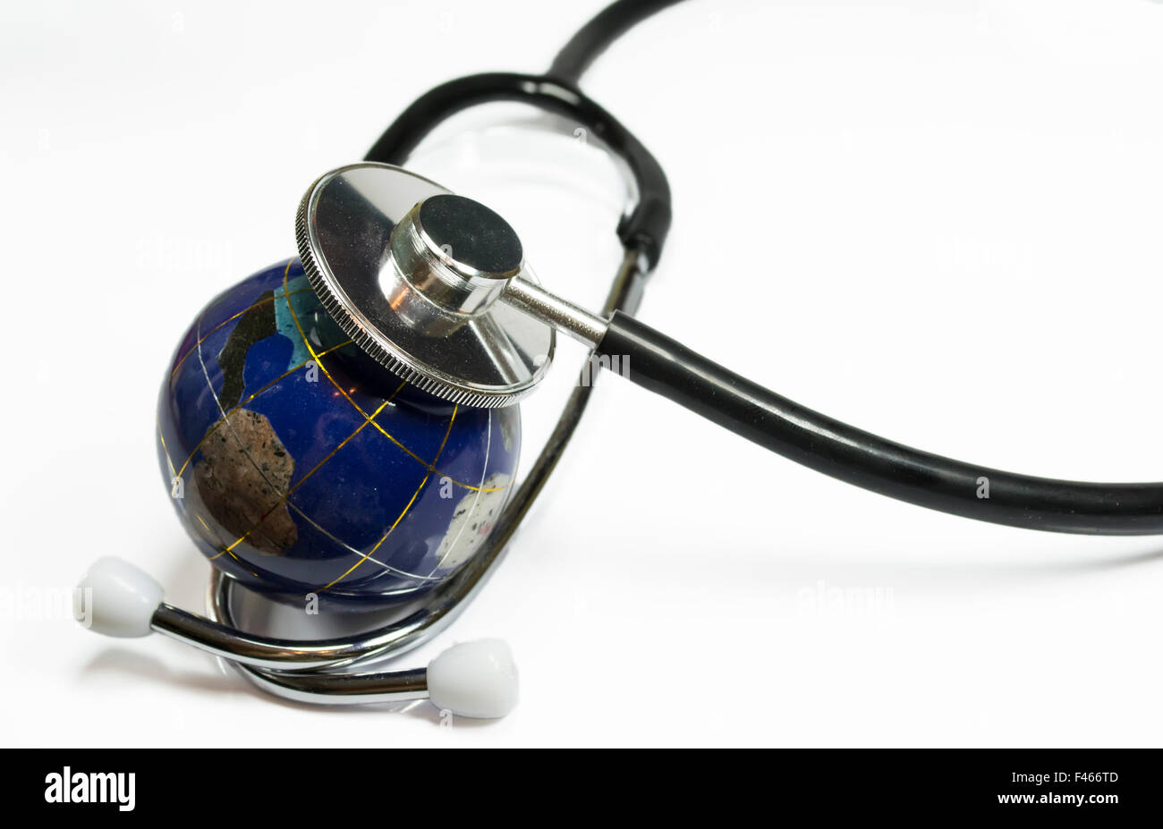 Massa di piccole dimensioni come il globo sotto la capsula di un medico di uno stetoscopio , immagine concettuale circa la salute ambientale del pianeta Foto Stock