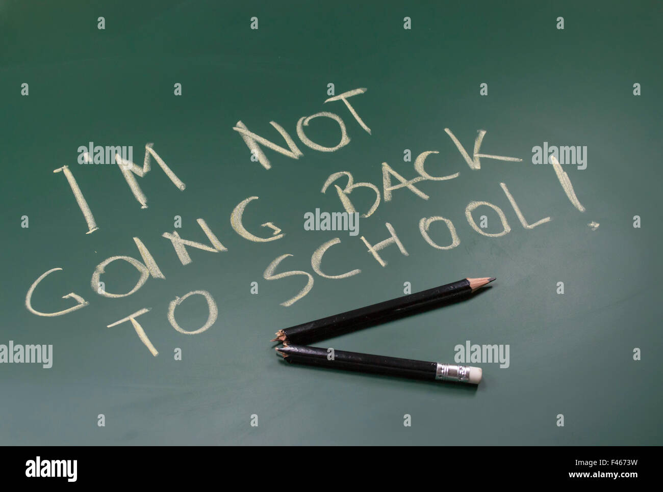 Messaggio scritto con il gesso sulla lavagna e rotto in metà matita di legno, immagine concettuale sulla scuola dropout e abbandonare Foto Stock