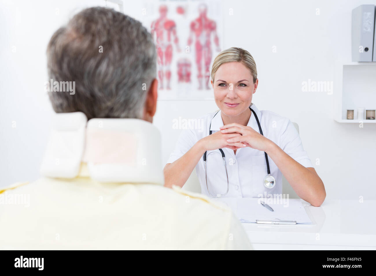 Medico guardando il paziente che indossa il rinforzo del collo Foto Stock