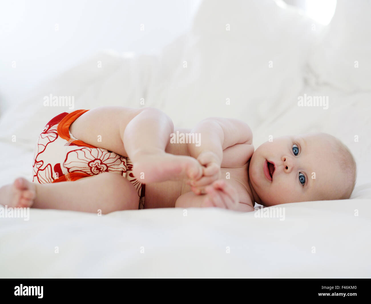 Un bambino gioca con i suoi piedi, Svezia. Foto Stock