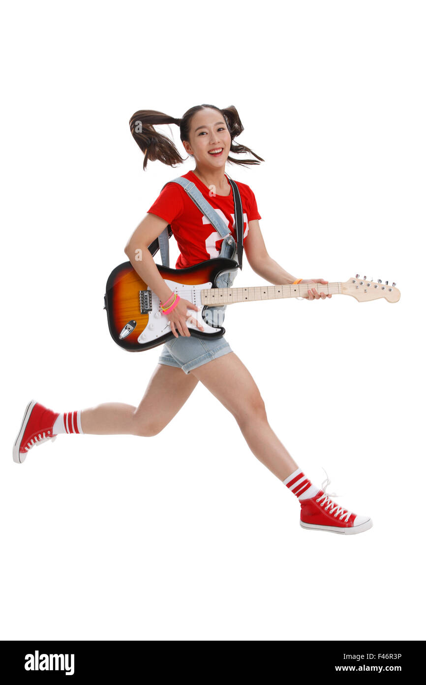 Giovane donna a suonare la chitarra Foto Stock