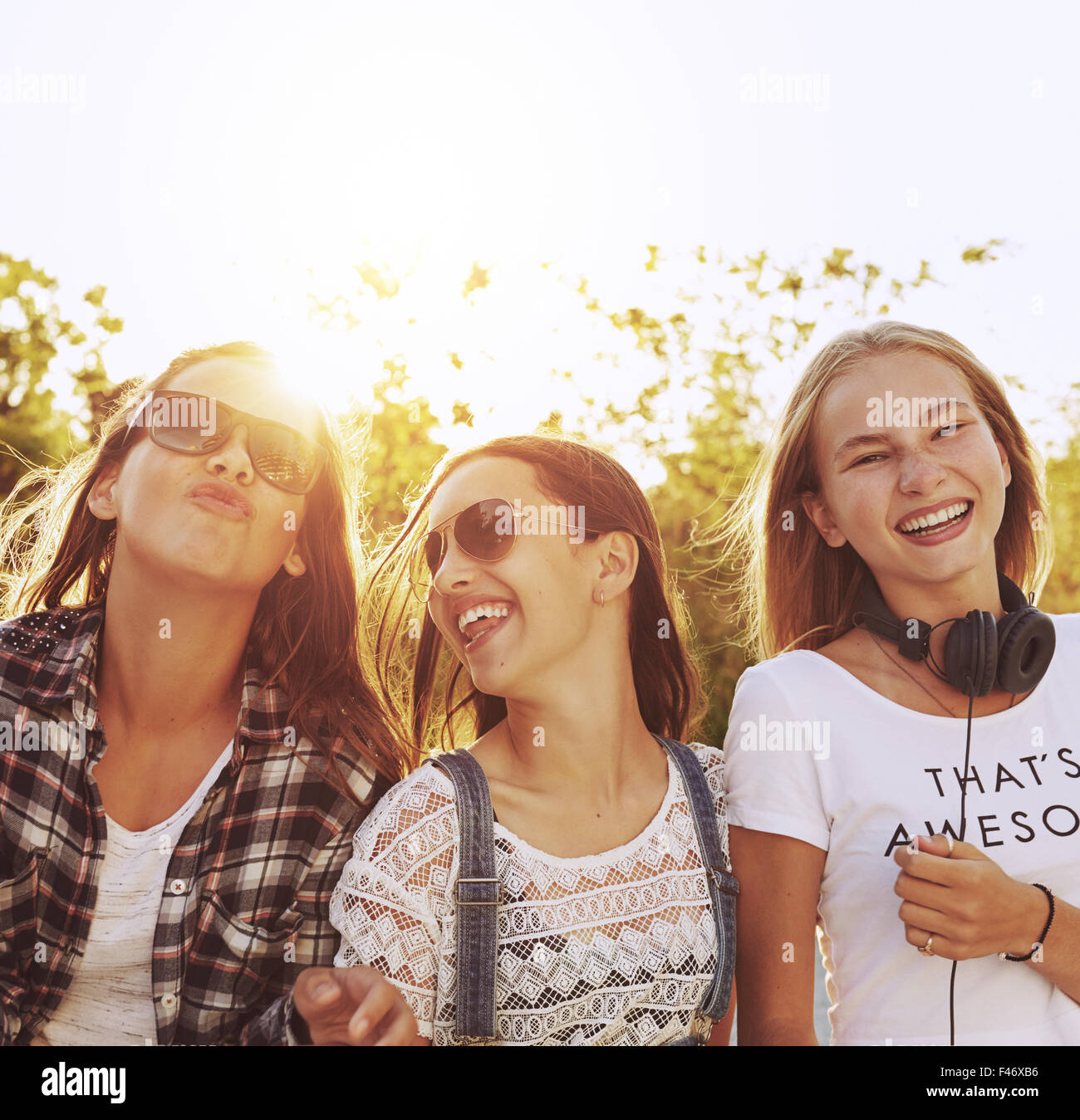 Tre ragazze adolescenti ridere appendere fuori in un giorno di estate Foto Stock