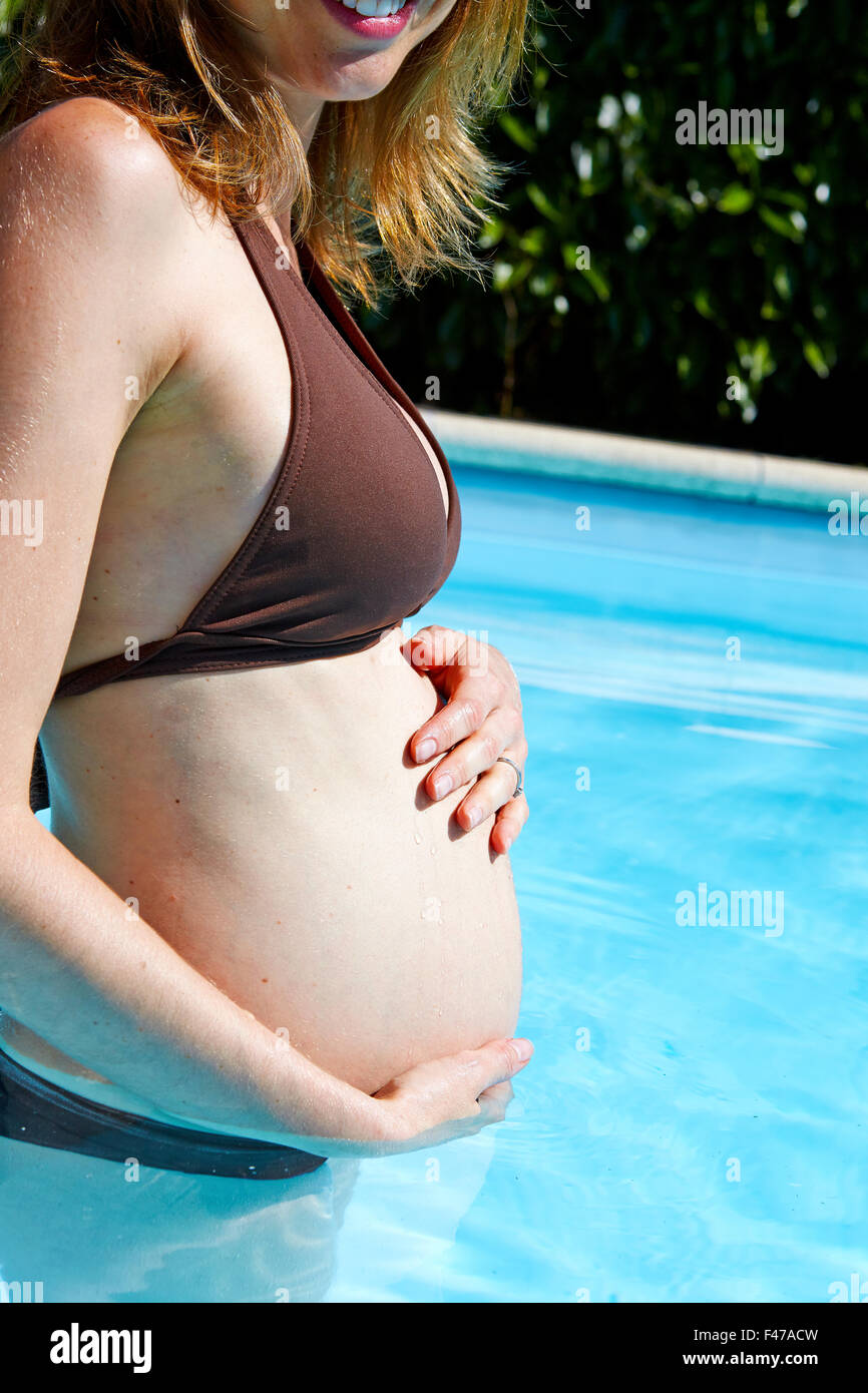 Donna incinta IN UN POOL Foto Stock