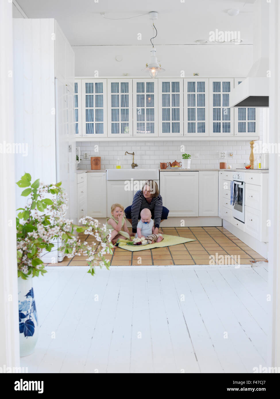 Madre e due bambini che giocano in cucina, Skane, Svezia. Foto Stock