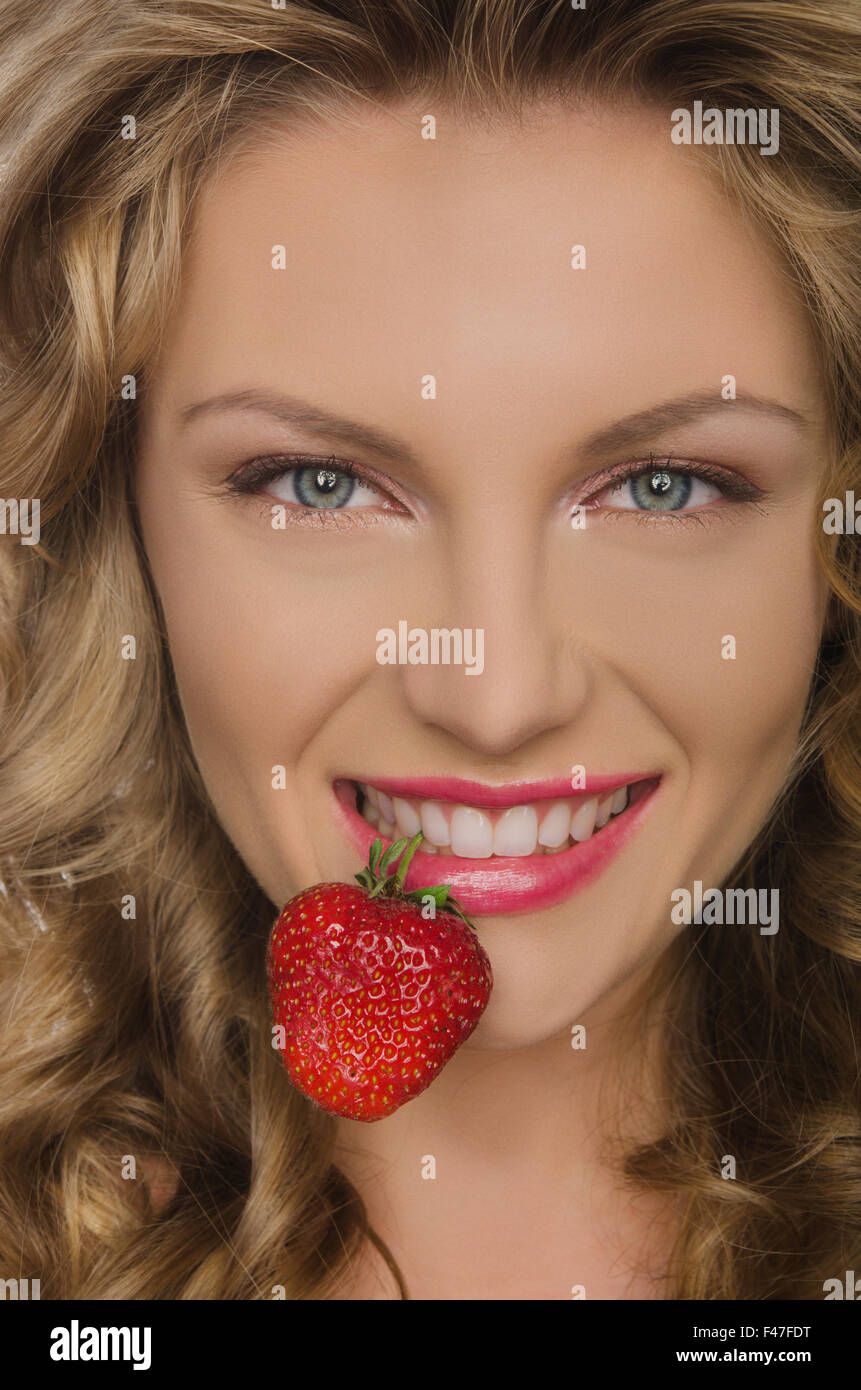 Bella donna con denti di fragola Foto Stock