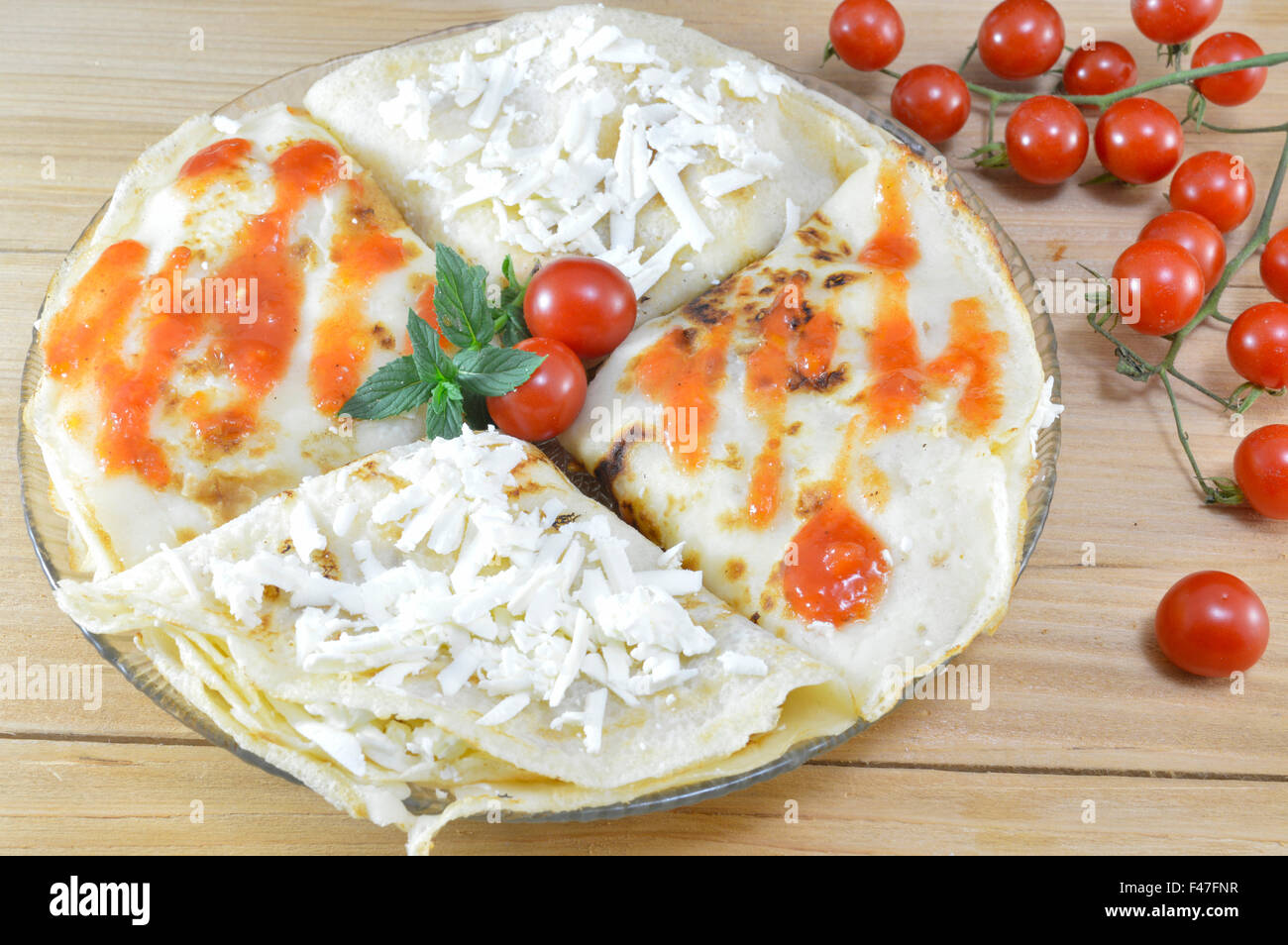 In casa i pancake salato servita e decorate con formaggio e pomodoro Foto Stock
