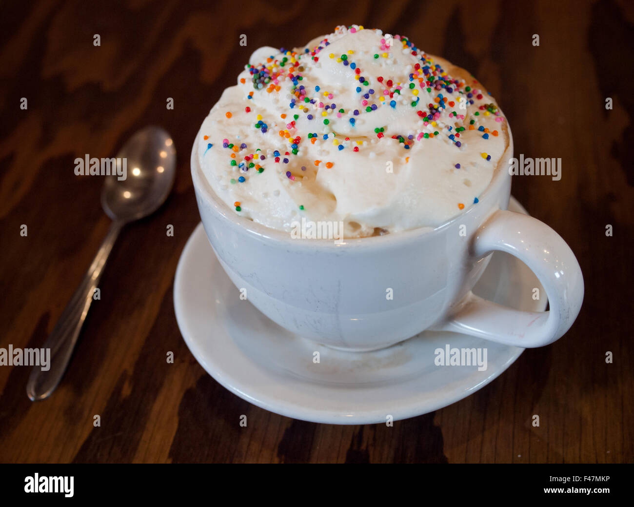 Un caldo Torta di compleanno latté con granelli colorati e panna montata dal d'Lish da Tish Café di Saskatoon, Saskatchewan, Canada. Foto Stock