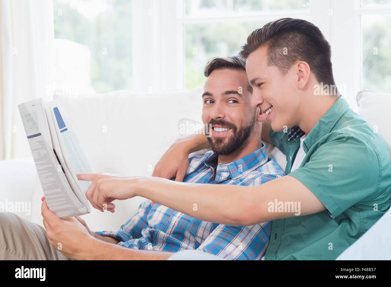 Coppia omosessuale uomini leggendo il giornale Foto Stock