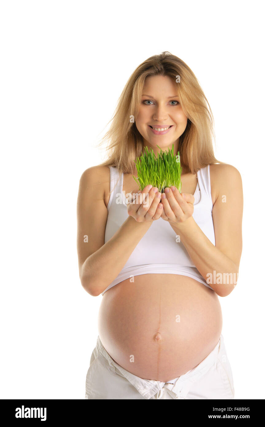 Donna incinta holding erba verde Foto Stock