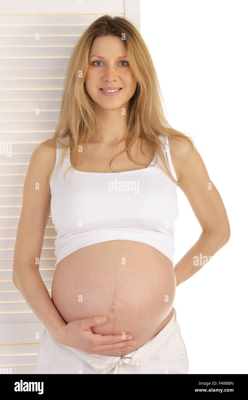 Donna incinta in piedi vicino alla porta Foto Stock