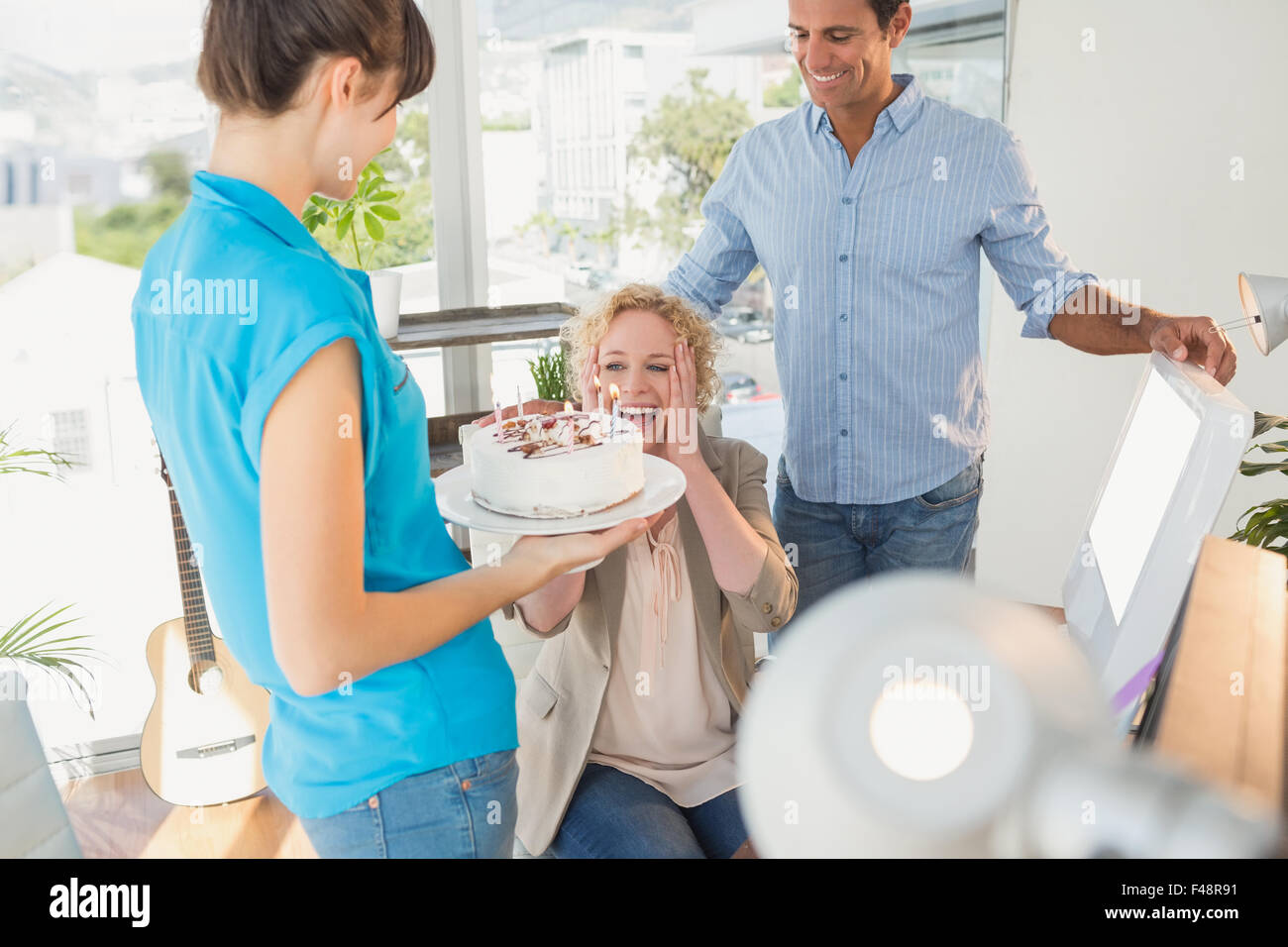 Imprenditrice soffiando le candeline sulla torta Foto Stock