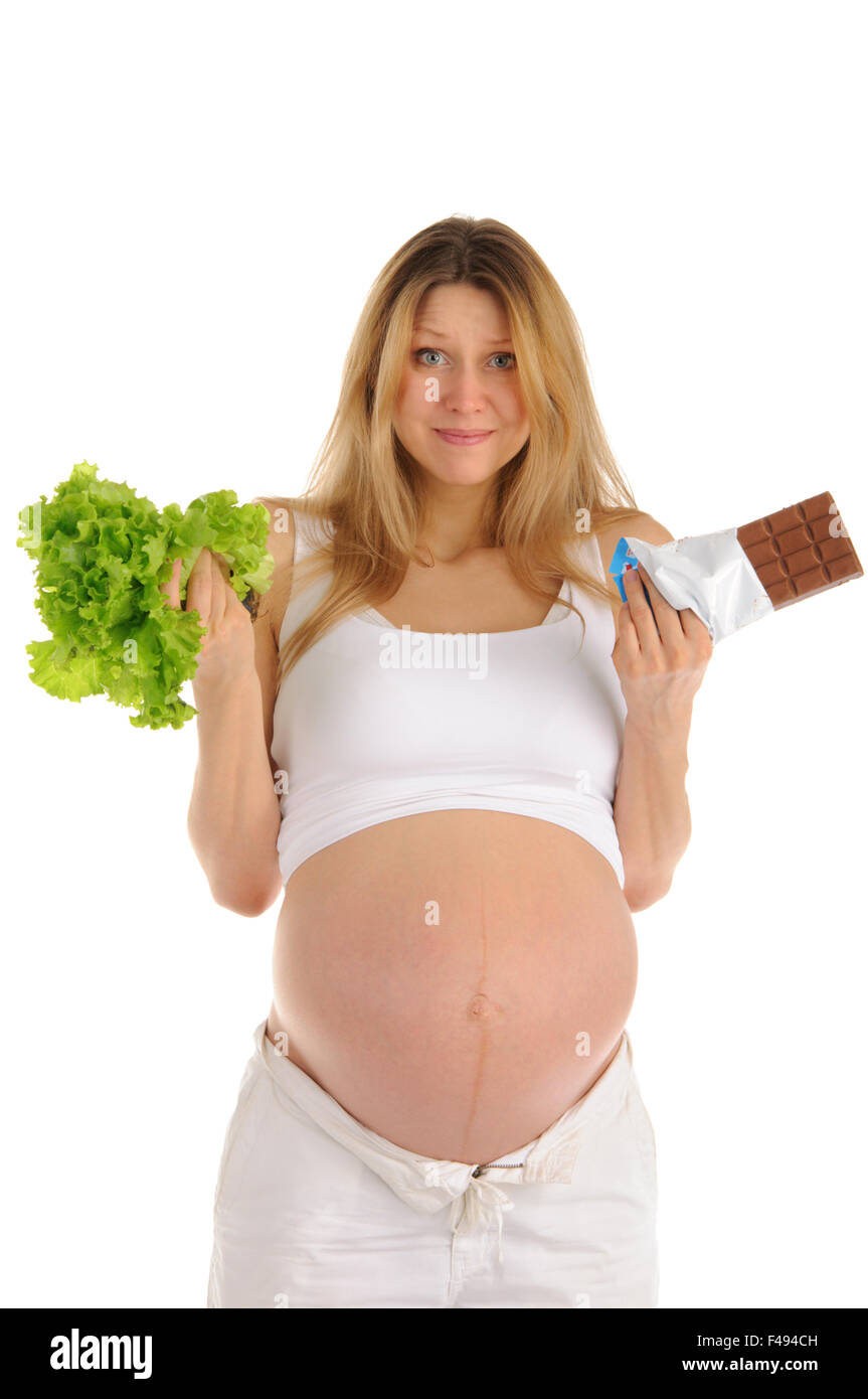 Donna incinta con cioccolato e lattuga Foto Stock