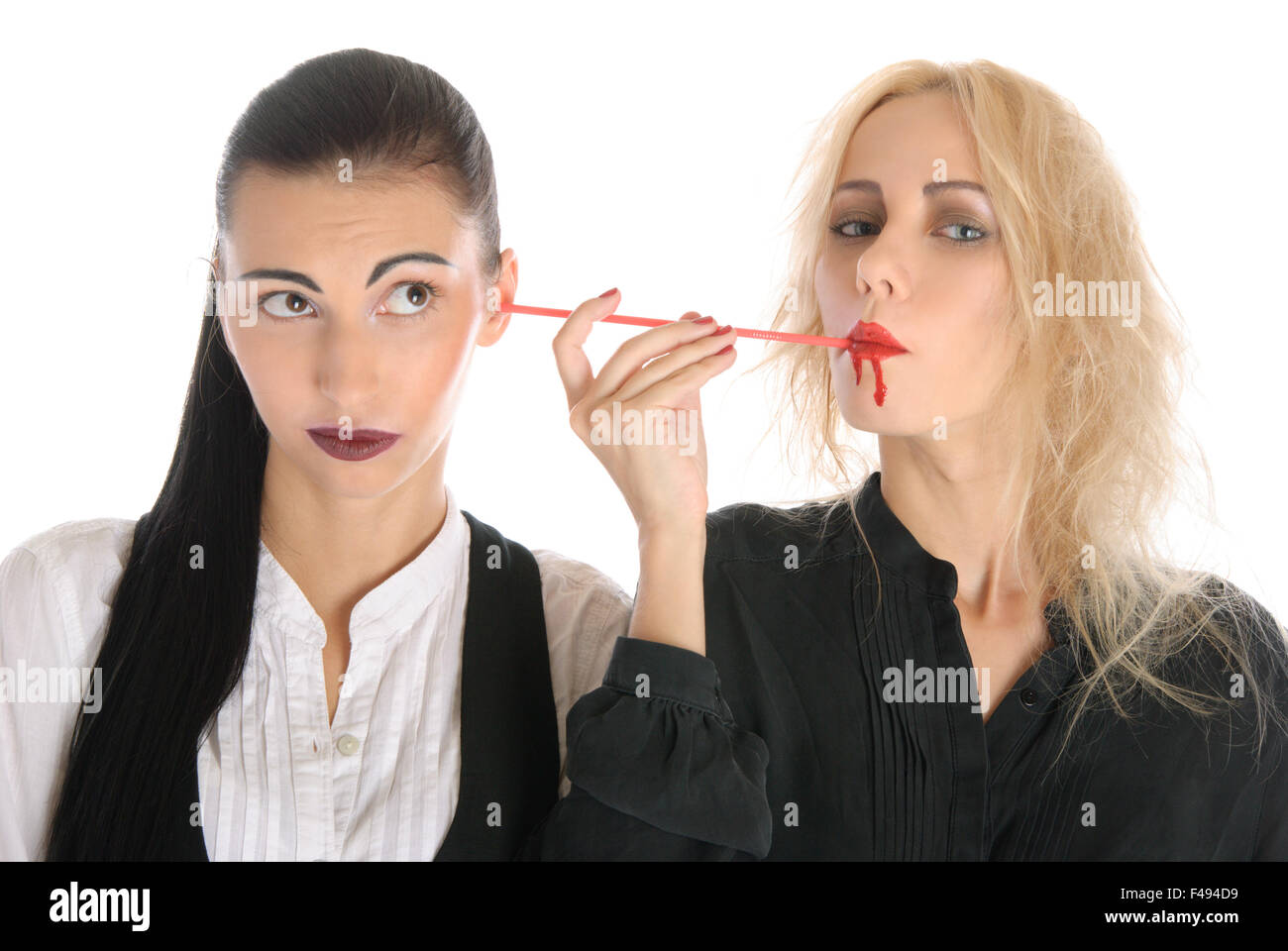 La donna aspira il sangue da un orecchio altra donna Foto Stock