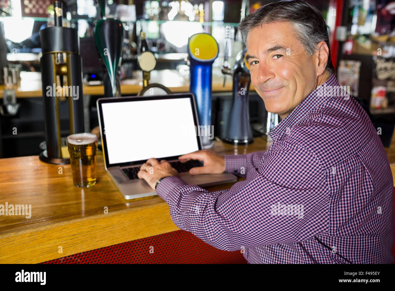 Uomo con i capelli grigi usando il suo computer portatile Foto Stock